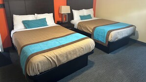 Two single beds with headboards, a nightstand with a lamp, and a framed picture on the wall.