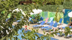 A pool area with lounge chairs and umbrellas. - Alecos Hotel Apartments (Paphos)