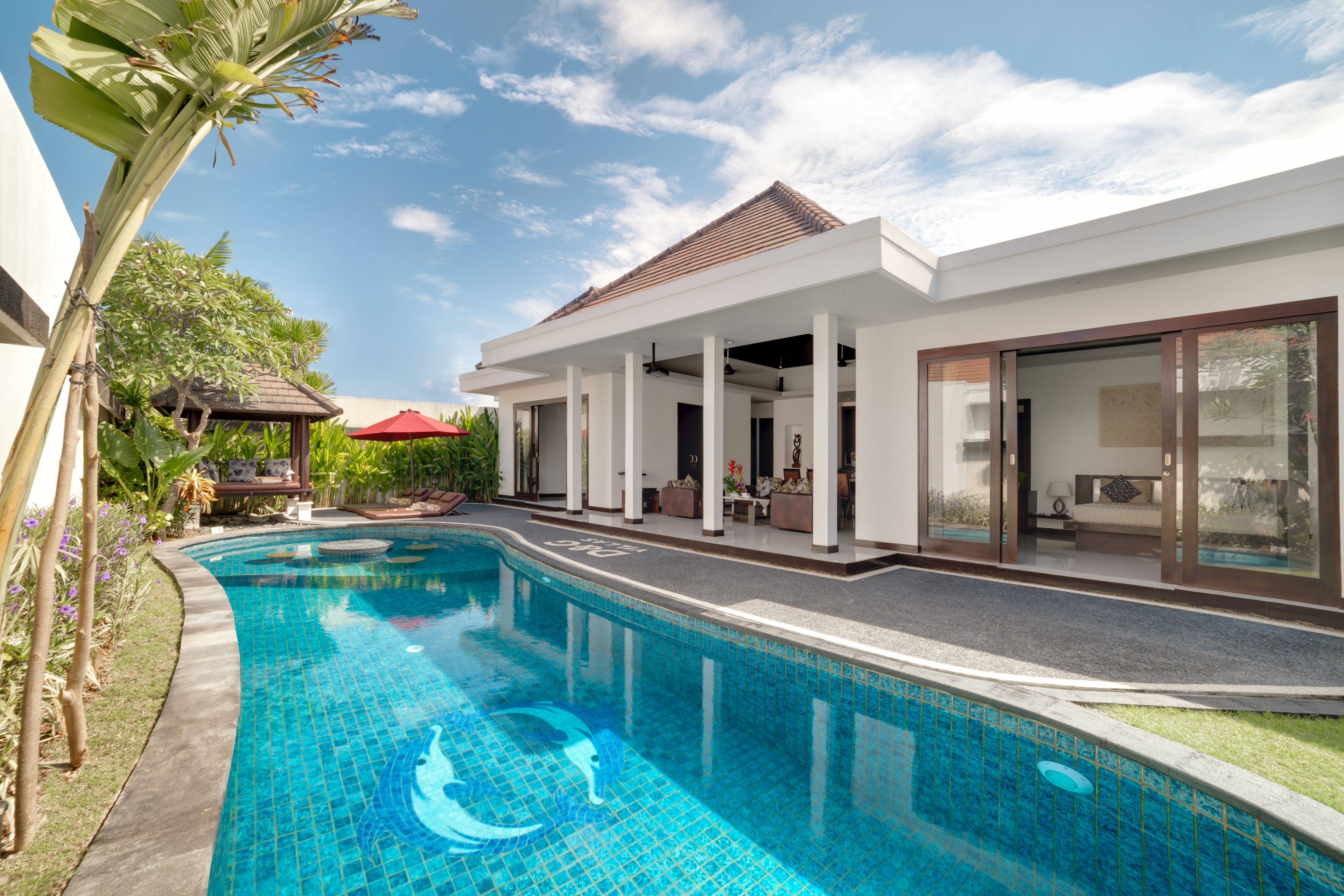 A modern house with a swimming pool, a covered patio, and a garden.