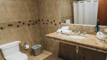 Een badkamer met toilet, wastafel en douche.