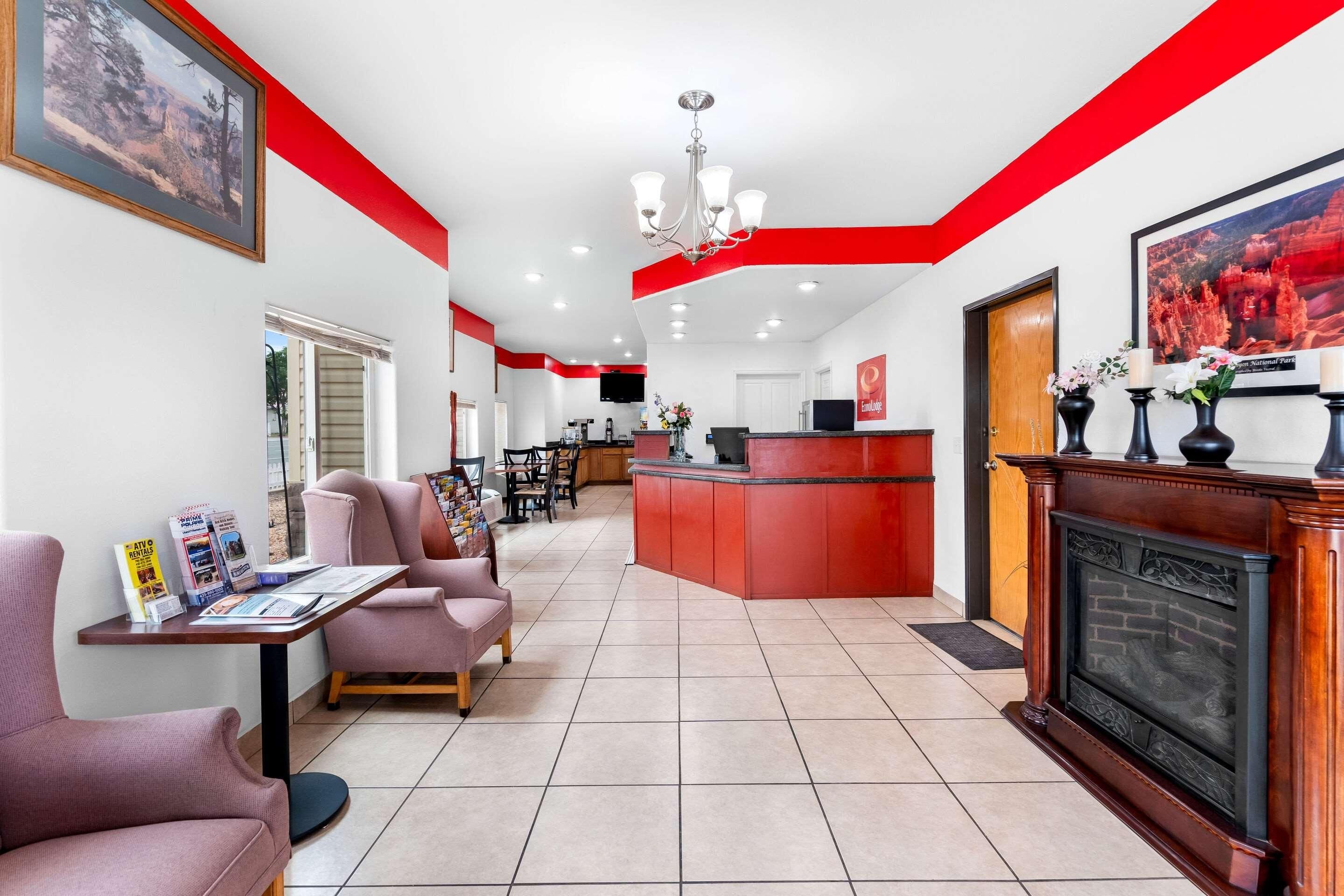 A hotel lobby with a reception desk, seating area, and a fireplace.