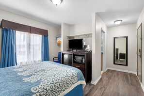 A hotel room with a bed, a desk with a computer, a television, and a mirror. - Econo Lodge Panguitch Near Bryce Canyon (Panguitch)