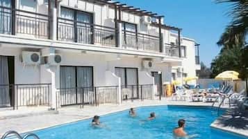 Una piscina al aire libre, sillones reclinables de piscina