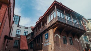A hotel with a prominent balcony, brick facade, and a sign indicating it is a light house. - Light House - Old City (Tbilisi)