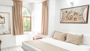 A hotel room with a large bed, a small bedside table, a mirror, and a window with curtains. - Hotel & Temazcal Hacienda de Melaque (San Patricio Melaque)