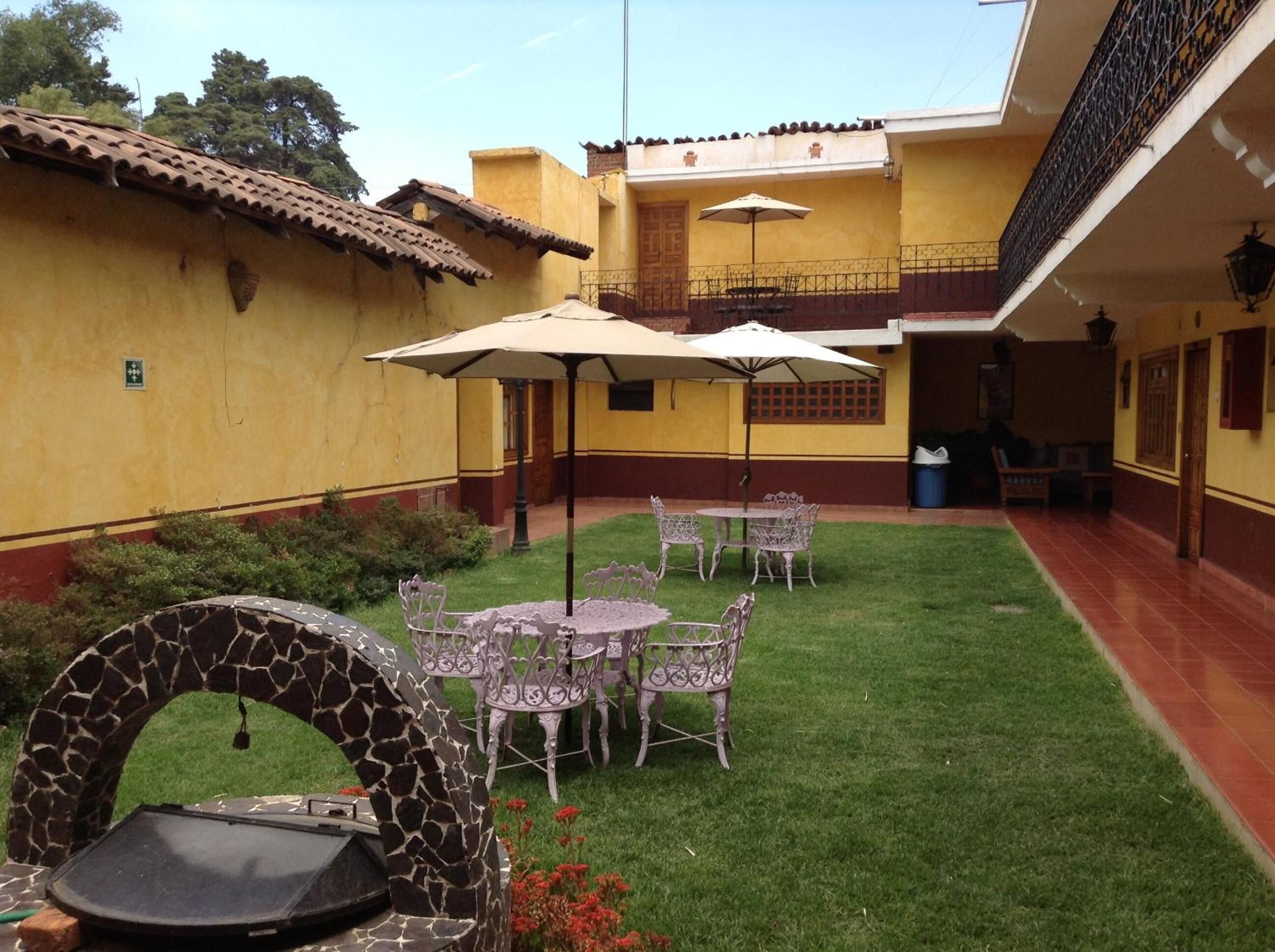 A courtyard with a dining area, outdoor furniture, and a decorative stone structure.