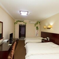 Una habitación de hotel con dos camas, un escritorio, un televisor y una puerta que da a otra habitación.
