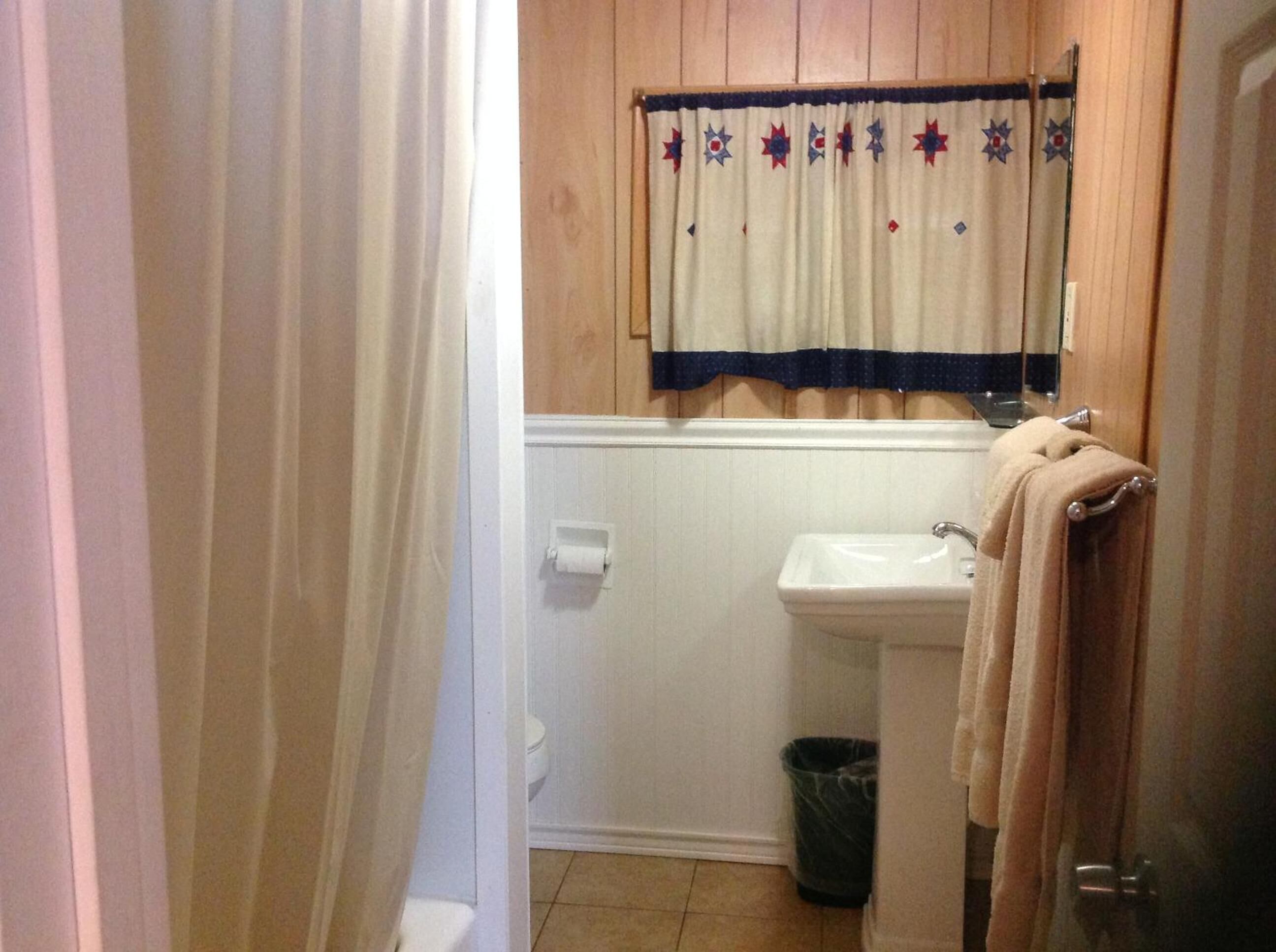 Une salle de bain équipée d’un lavabo, de toilettes et d’un porte-serviettes.