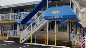 Un motel avec un auvent bleu, un escalier et un parking.