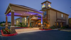 A Best Western hotel with a covered entrance, outdoor seating, and a clear sign indicating a 14-foot clearance. - Best Western Casino Inn (Vinton)