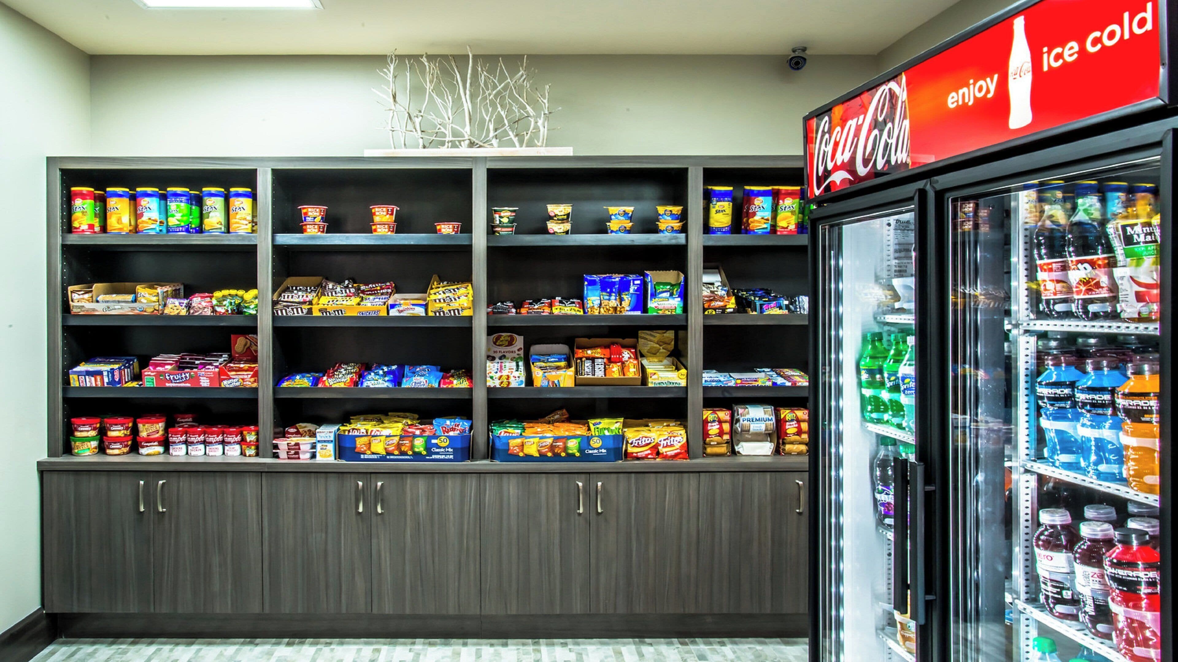 A snack and beverage display in a store with a Coca-Cola sign above.