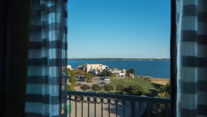 A view from a balcony overlooking a coastal area with buildings, a parking lot, and a body of water. - Holiday Inn Express & Suites Garland E - Lake Hubbard I30 by IHG (Garland)