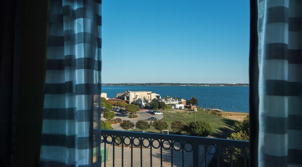 A view from a balcony overlooking a coastal area with buildings, a parking lot, and a body of water. - Holiday Inn Express & Suites Garland E - Lake Hubbard I30 by IHG (Garland)