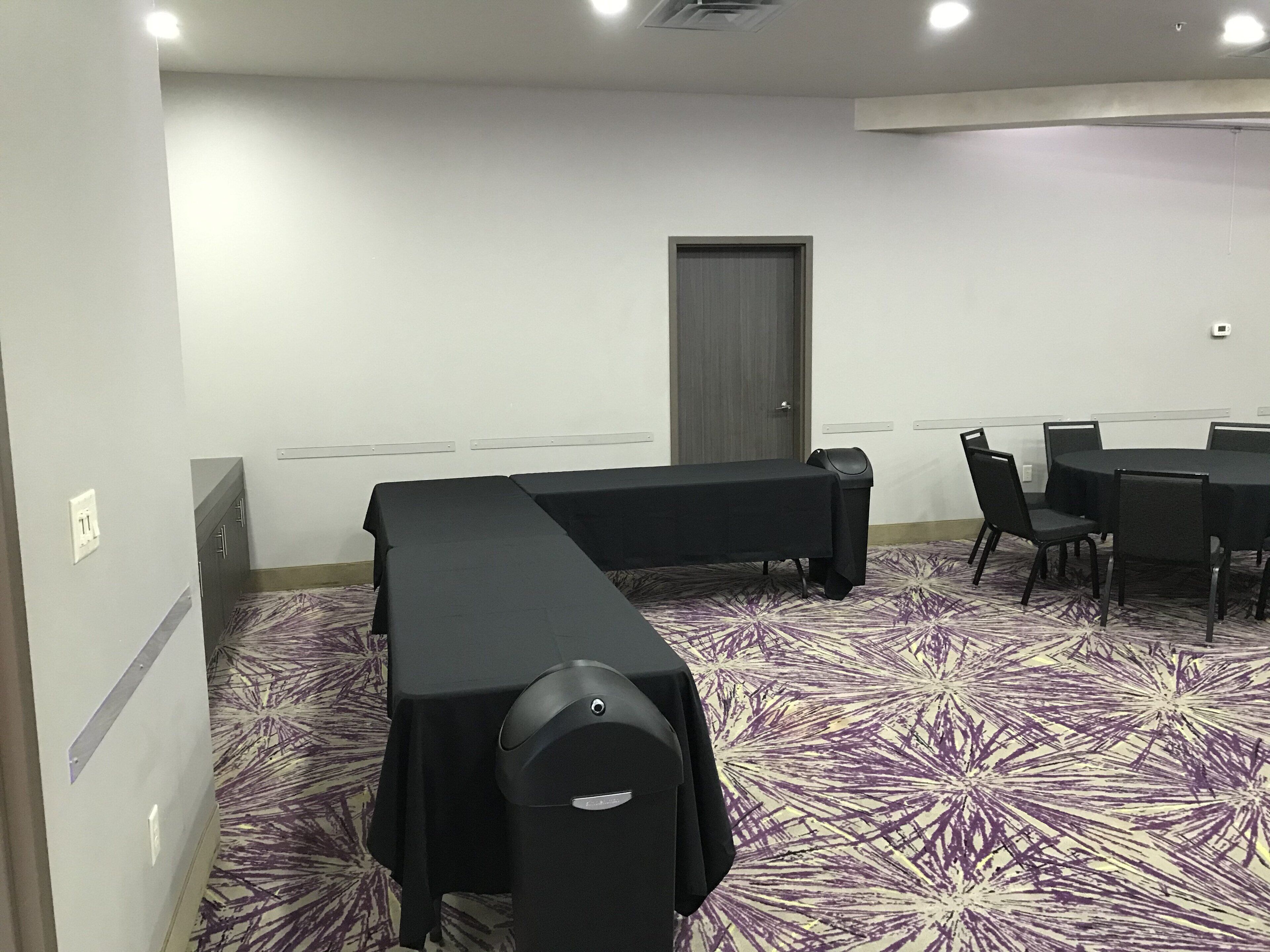 A conference room with a long table, chairs, and a door.