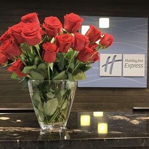 Vaso de vidro com rosas vermelhas em um balcão no Holiday Inn Express.