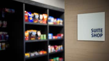 A sign indicating a 'SUITE SHOP' in a store with shelves stocked with various products.