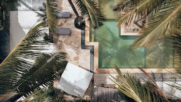 Relax by the resort's pool surrounded by palm trees and lounge chairs.