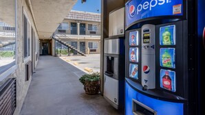 A Pepsi vending machine at a building entrance with a clear view of the building's exterior. - Continental Lodge (Oakland)