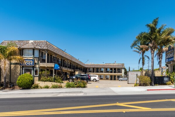 A motel with a sign reading "Continental Lodge" and a parking lot with several cars. - Continental Lodge (Oakland)