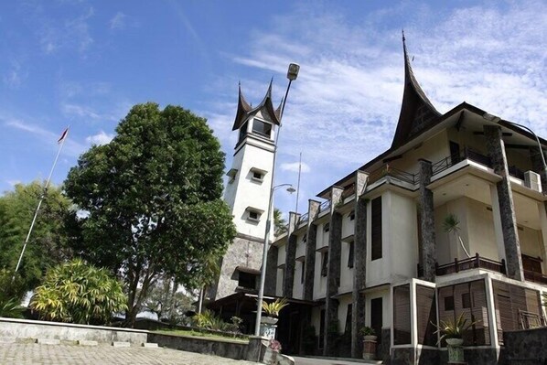 A traditional building with a prominent tower and a multi-story structure with balconies. - Campago Resort Hotel (Bukittinggi)