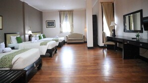 Una habitación de hotel con dos camas, un escritorio, una silla y un sofá.