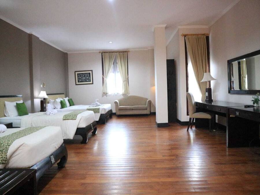 Une chambre d’hôtel avec deux lits, un bureau, une chaise et un canapé.