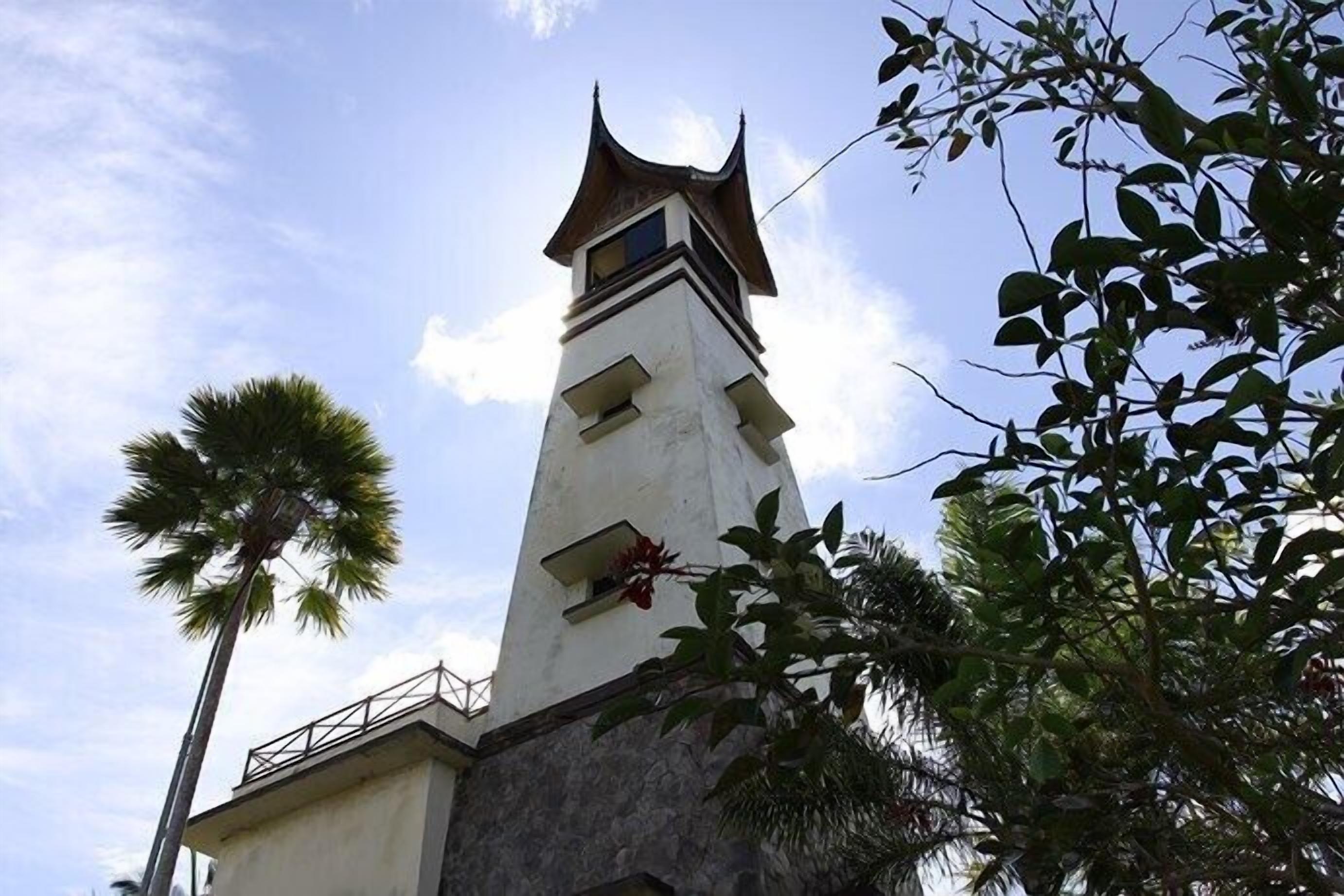 Una torre alta y delgada con techo puntiagudo y un balcón.