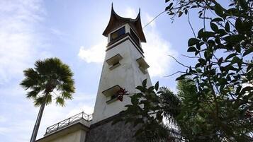 Una torre alta y delgada con techo puntiagudo y un balcón.