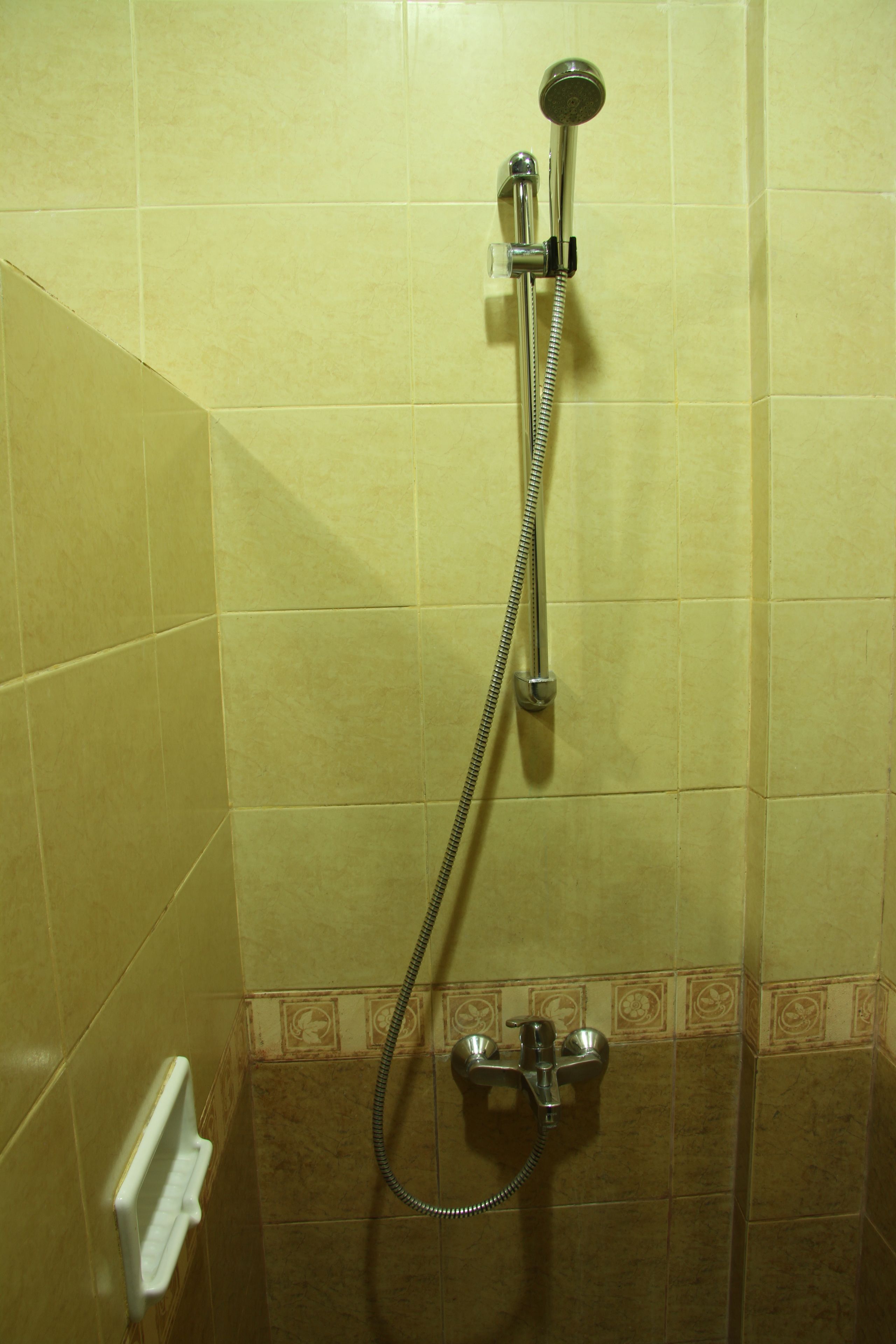 Una ducha con cabezal de ducha de mano y grifo empotrado.