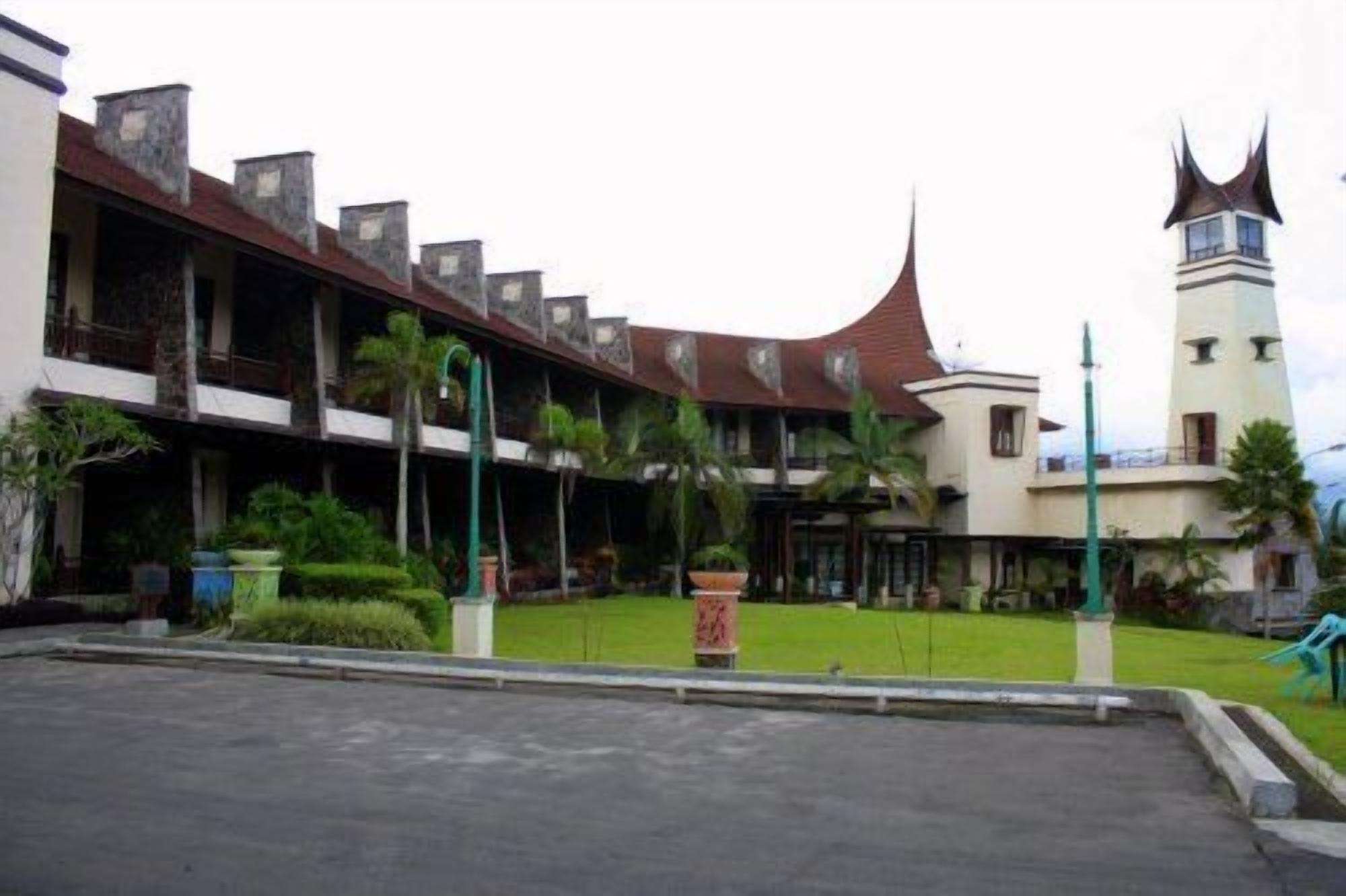 A building with a traditional architectural style, featuring a prominent tower and a covered walkway with multiple levels.