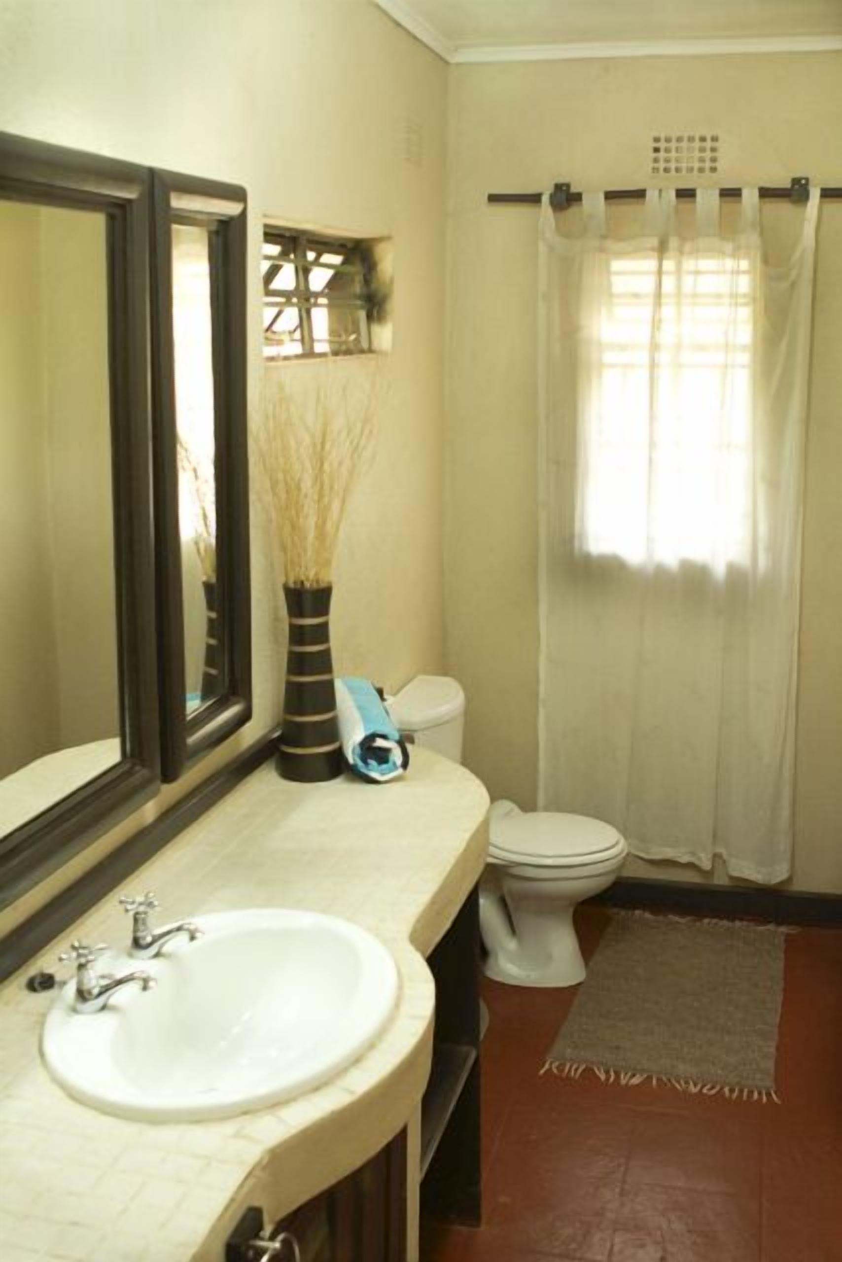 Un baño con lavabo, inodoro y cortina de ducha.