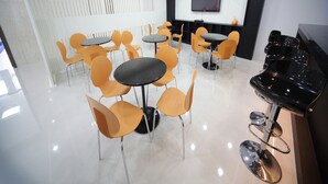 A modern conference room with multiple tables and chairs, a large flat-screen TV, and a piano. - Sol Guest House Haeundae (Busan)