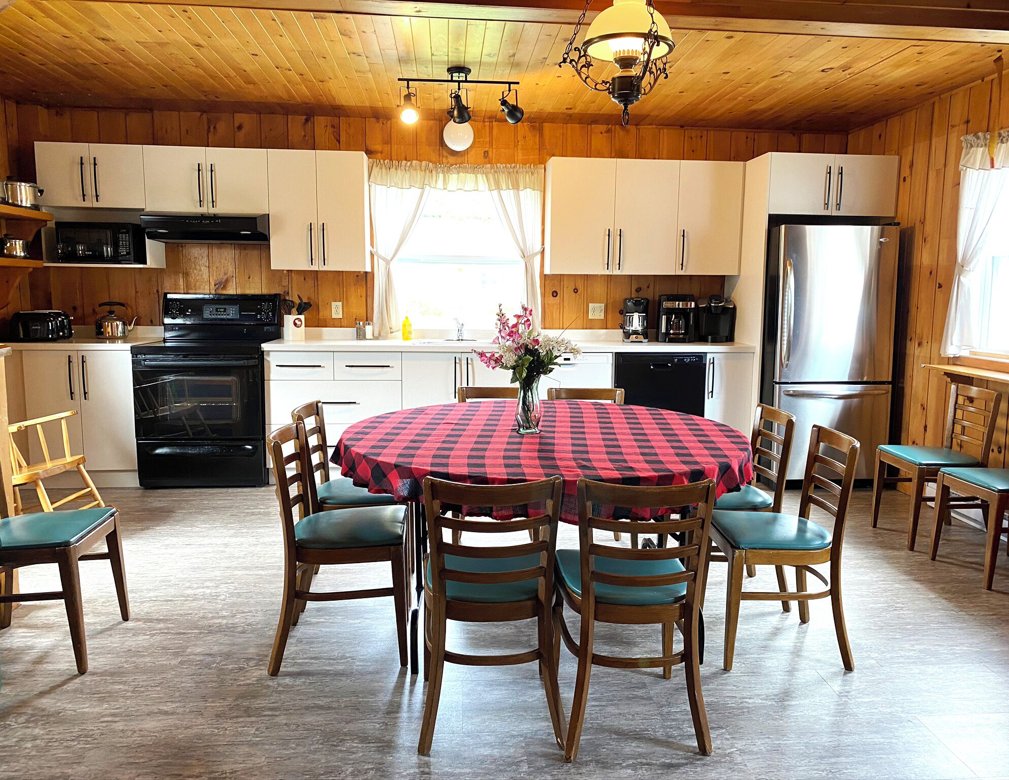 Una cocina acogedora con armarios de madera, una isla central y una mesa de comedor con sillas.