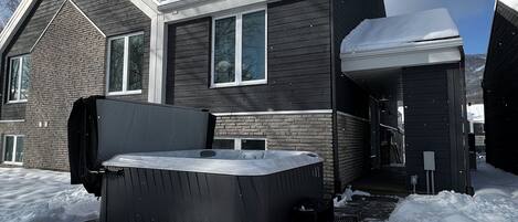 A two-story house with a covered hot tub and a garage.