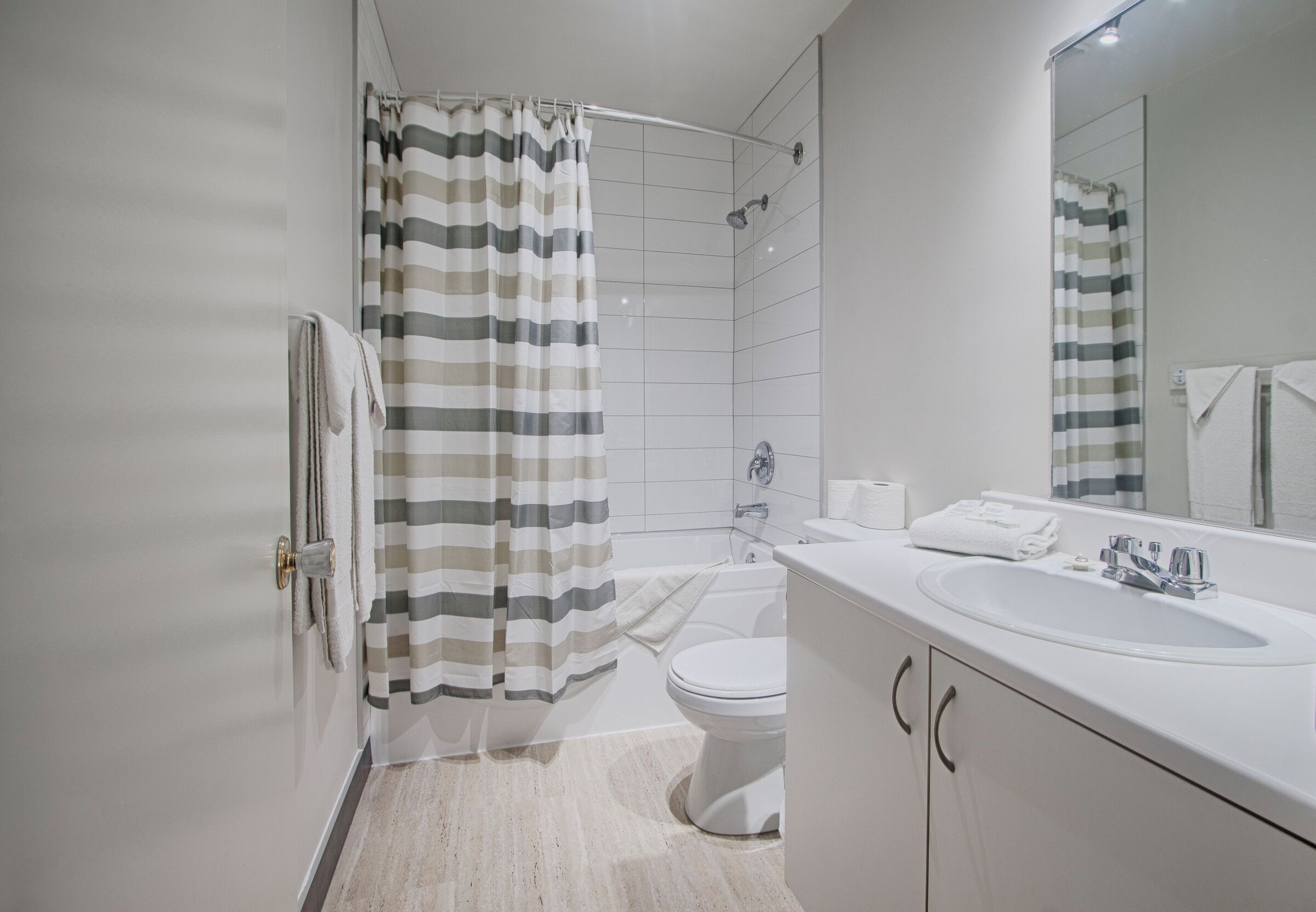 Un baño moderno con ducha, inodoro y lavamanos.