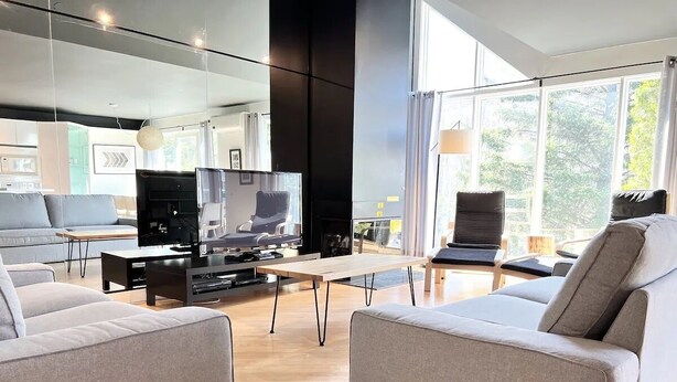 Una sala moderna con dos sofás, una mesa de centro y un televisor.