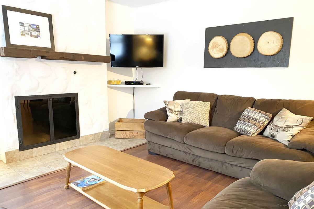 A living room with a fireplace, a television, a sofa, and a coffee table.