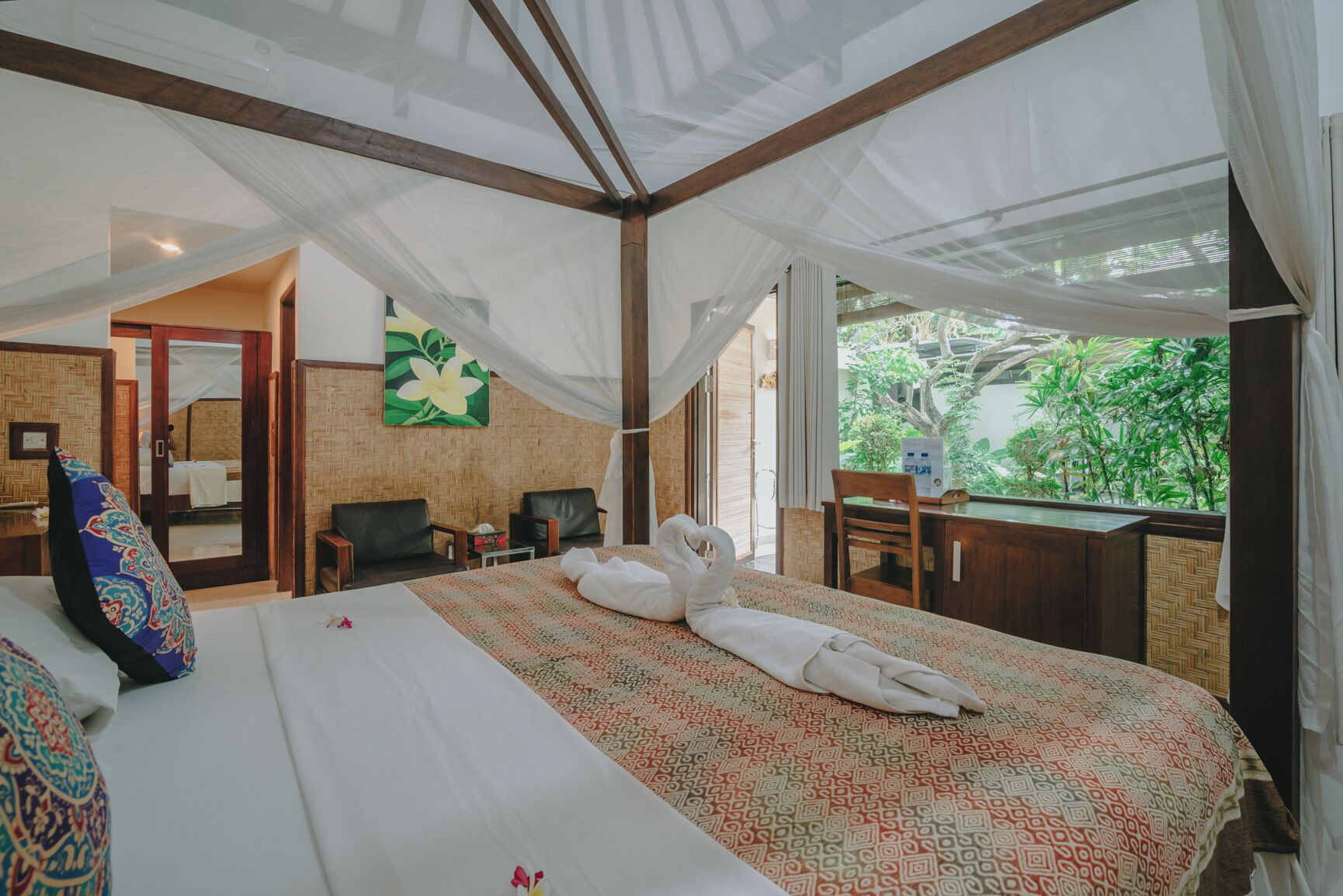 Ein Zimmer mit Bett, Schreibtisch und Blick auf Grün.