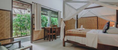 A bedroom with a bed, a desk, and a chair.