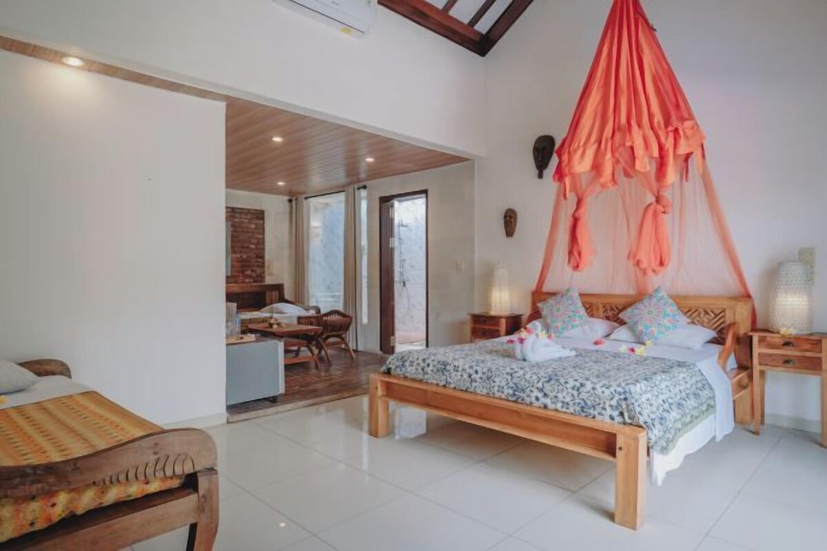 A bedroom with a wooden bed, a canopy, and a view of a dining area.