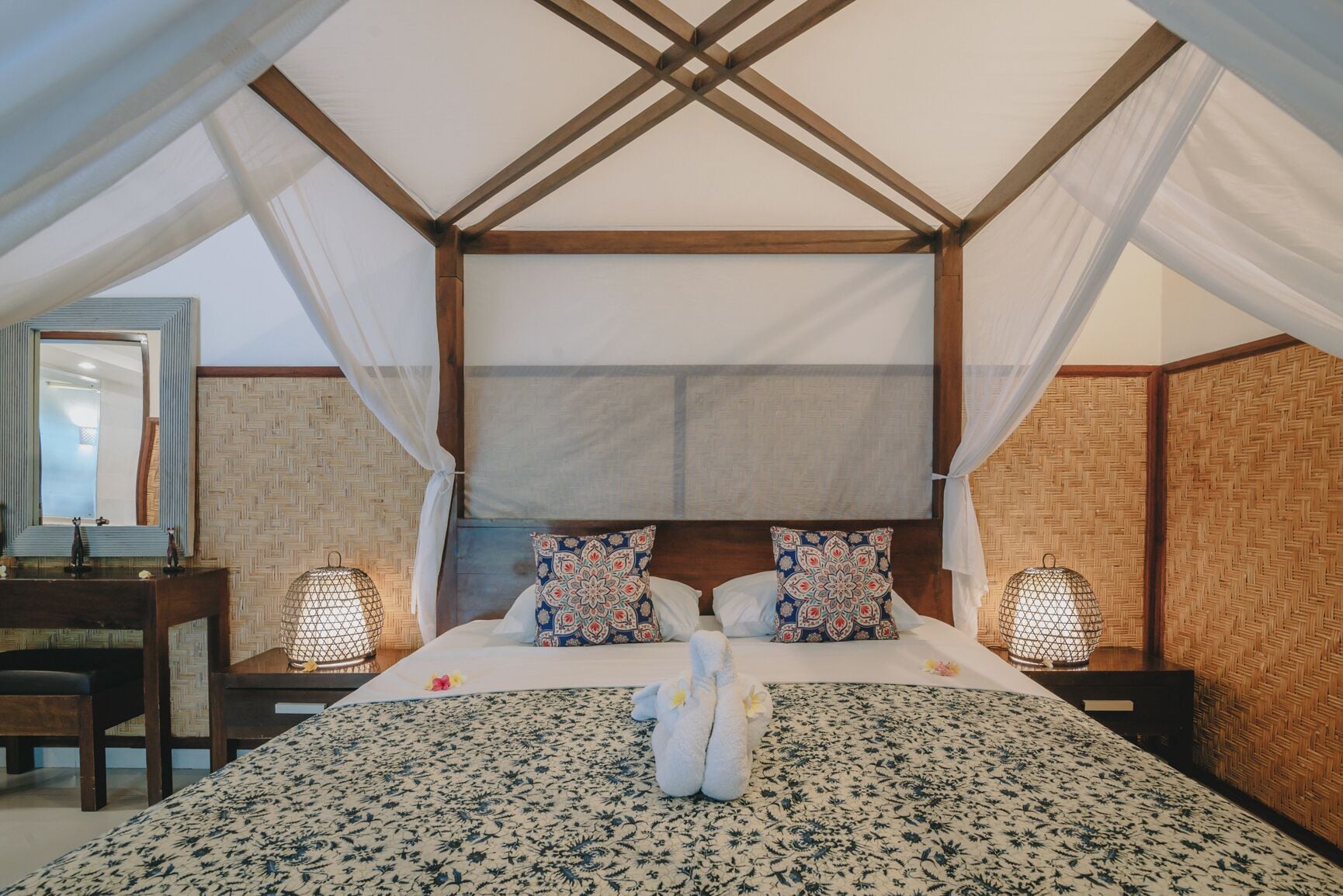 Ein geräumiges Schlafzimmer mit einem großen Bett, zwei Nachttischen, einem Beistelltisch und einem Baldachinbett.
