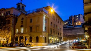 A hotel with a bell tower, a parking sign, and a street with cars. - Hearth Hotel (Rome)