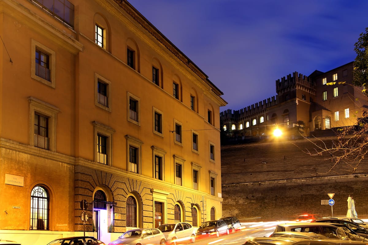 A historic building with arched windows and a sign reading "VIA SANTAMARIA".