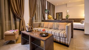 A modern living room with a striped sofa, a small table with drinks, a television, and a decorative plant. - Hearth Hotel (Rome)
