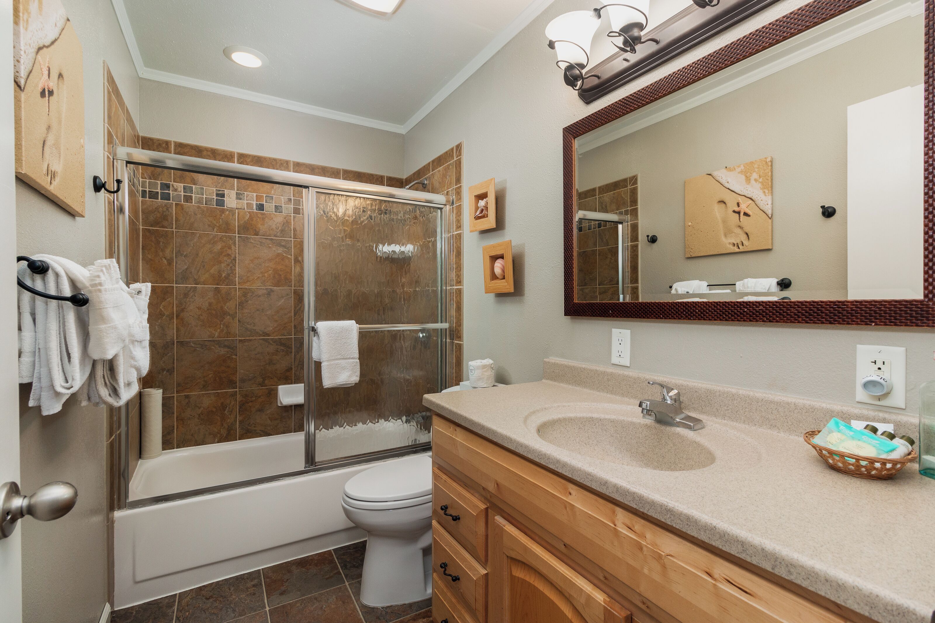 A bathroom with a glass-enclosed shower, a bathtub, a toilet, and a vanity with a sink.