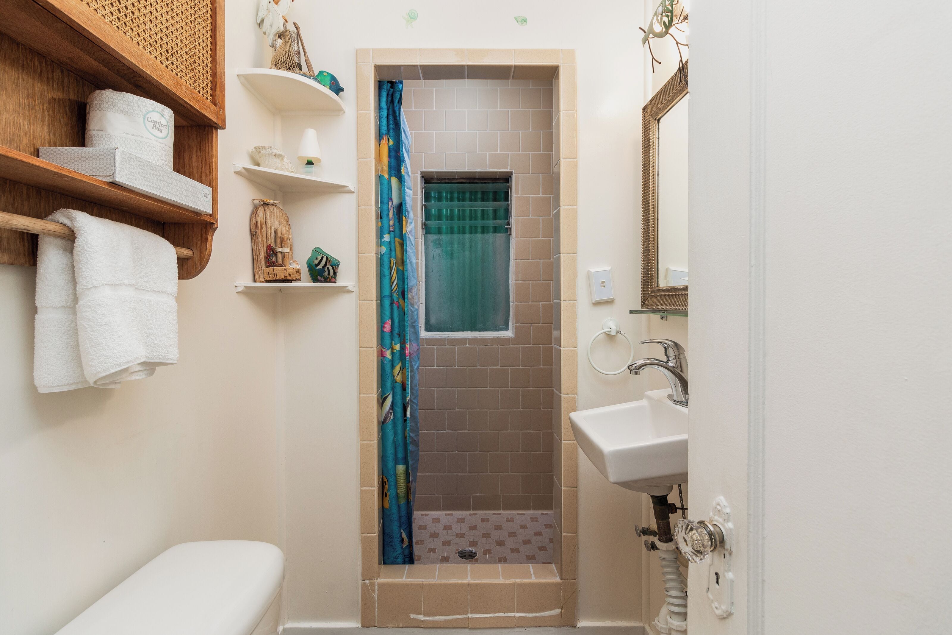 Een kleine badkamer met een douche, toilet en wastafel.