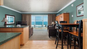 A compact room with a kitchen area, a dining table, and a view of the ocean. - Ocean Terrace Condominiums (Lincoln City)