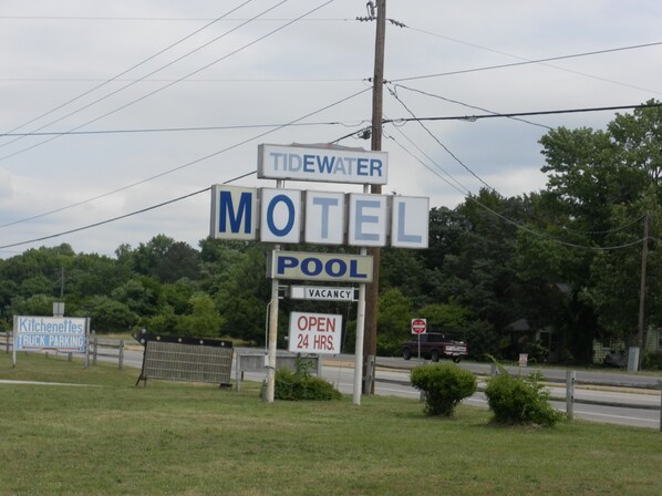 Señal de motel que indica 'Tidewater Motel' y 'Piscina', mostrando sus servicios.