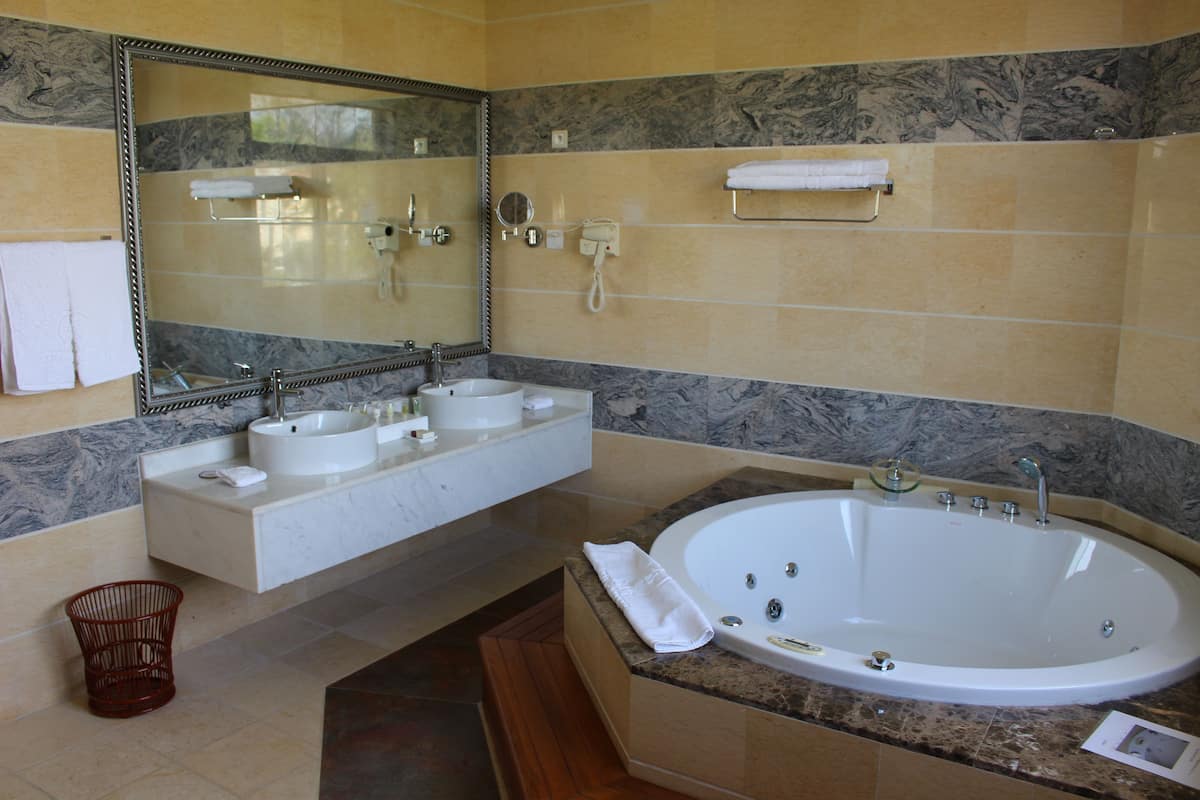 deluxe suite | bathroom | combined shower/bathtub, jetted bath, rainfall showerhead