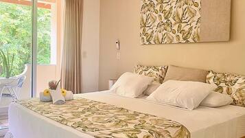 A bedroom with a bed, a ceiling fan, a window with curtains, and a wall-mounted artwork.